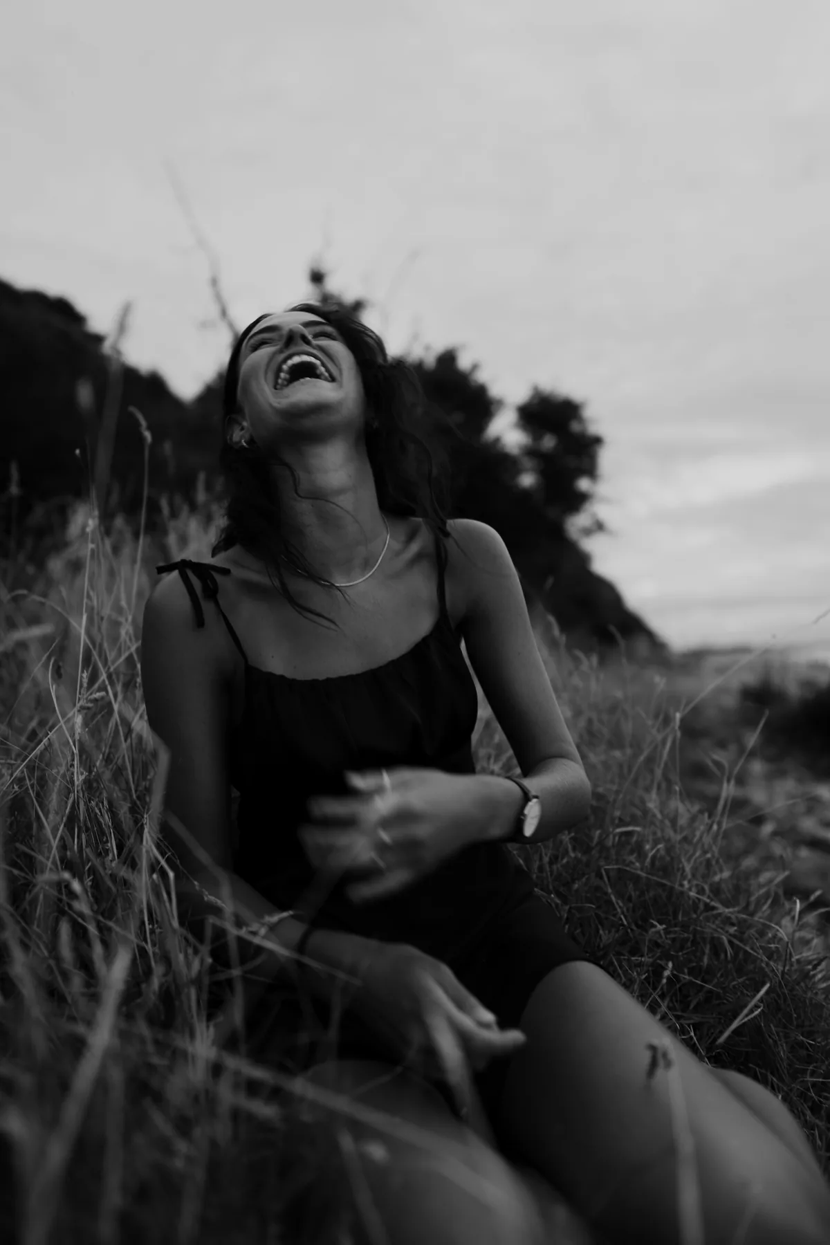 Adult laughing outdoors in a candid black and white portrait