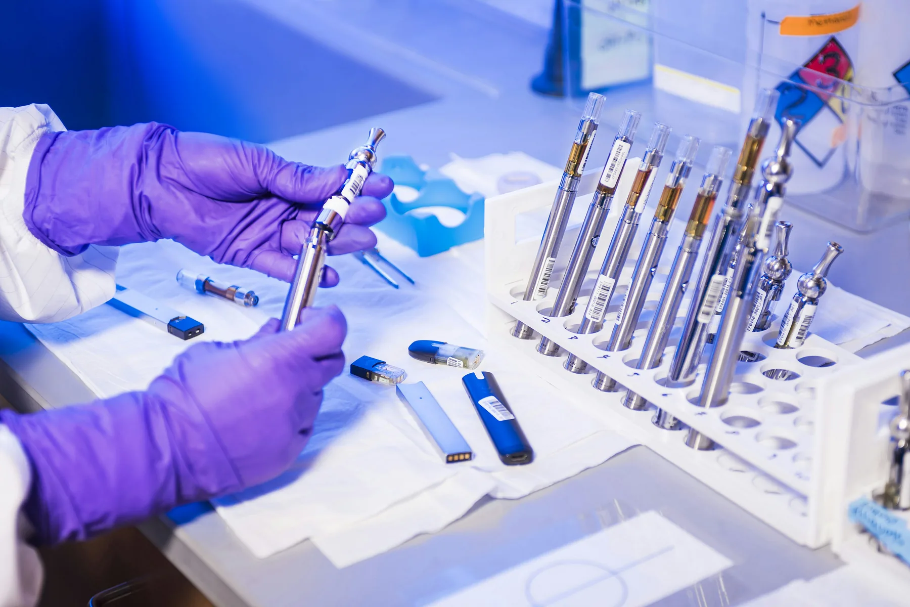 Gloved technician working with vape components in a clean laboratory